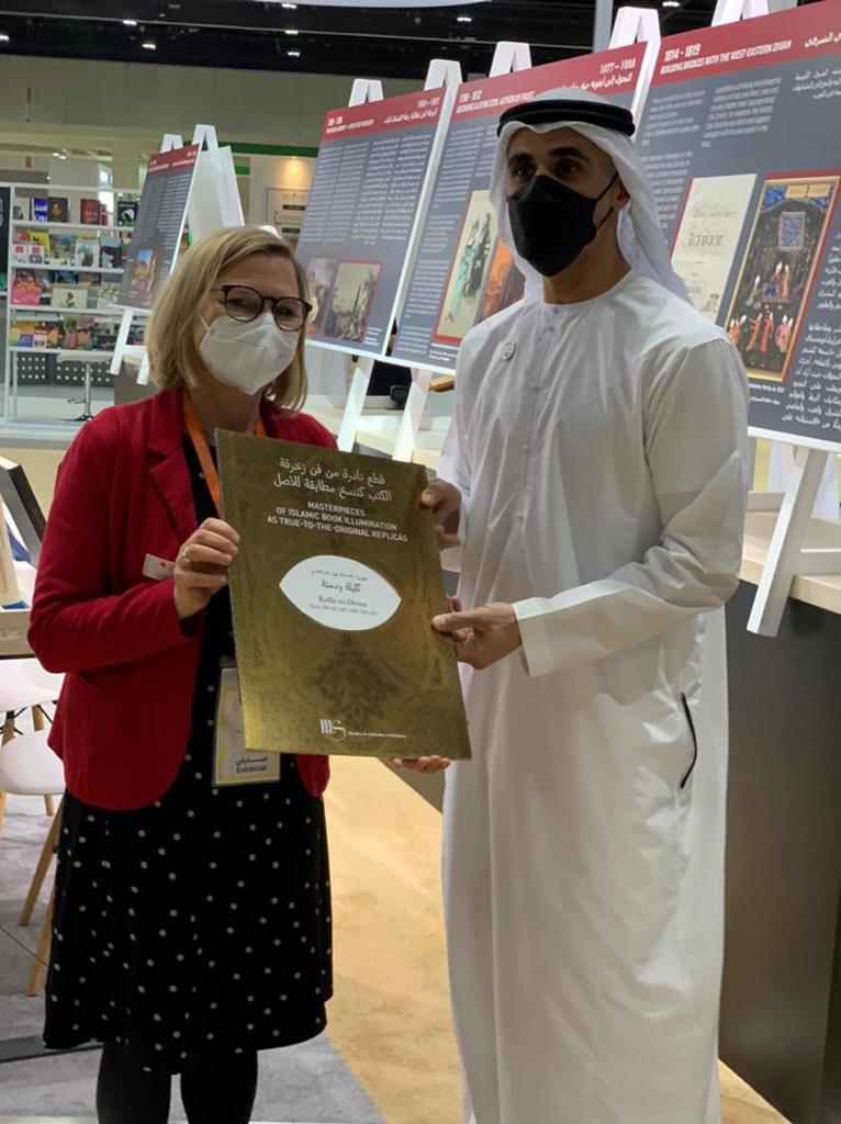 Fr. Claudia Kaiser, Vizepräsidentin der Frankfurter Buchmesse überreicht feierlich eine edle goldene Mappe an den Sohn des Kronprinzen