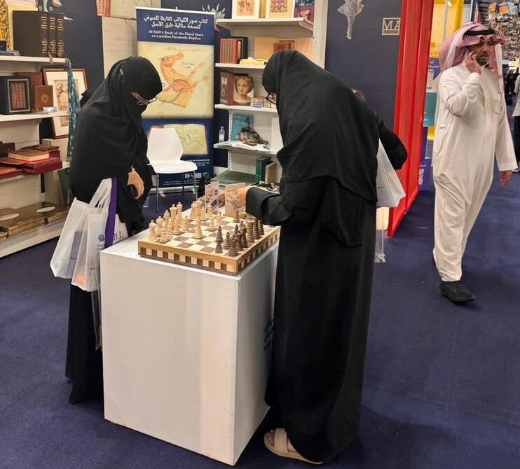 Messeeindrücke von der Buchmesse in Riad. Zwei Frauen spielen Schach.