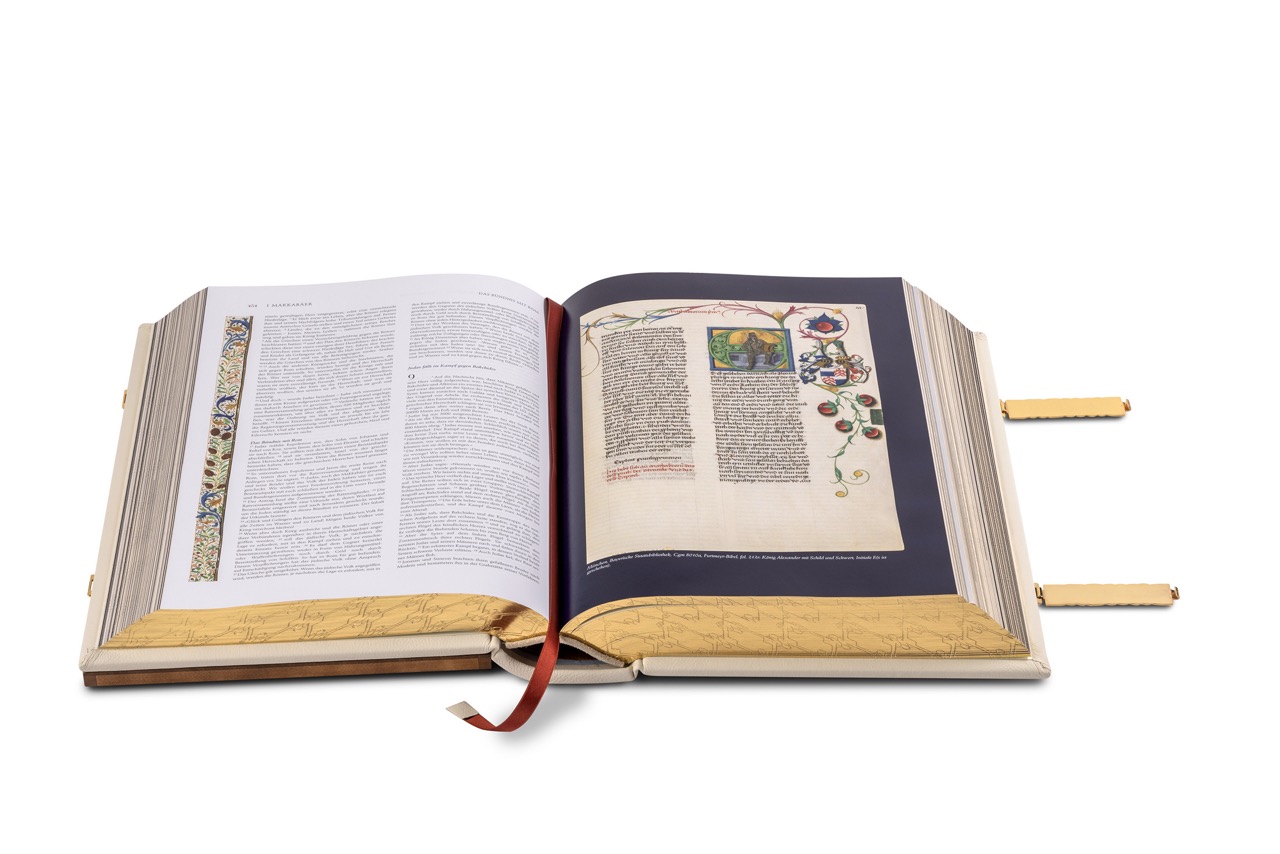 Aufgeschlagene Bibel. Zu sehen ist das luxuriöse Leseband mit edler Ledereinfassung sowie eine Doppelseite mit Miniatur und Text.
