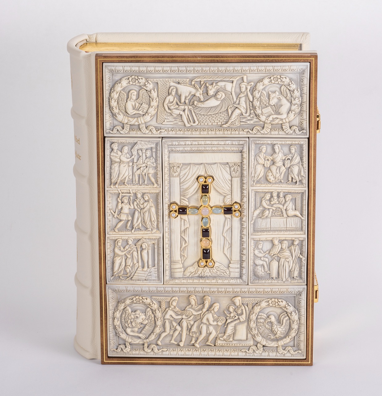 Bible front cover: binding with ivory replicas in a fine wooden frame. In the centre of the cover you can see a magnificent gold-plated cross set with precious stones.